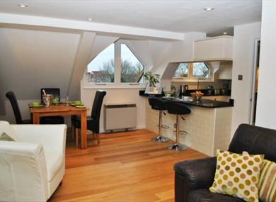 Penthouse kitchen opening to light/spacious lounge