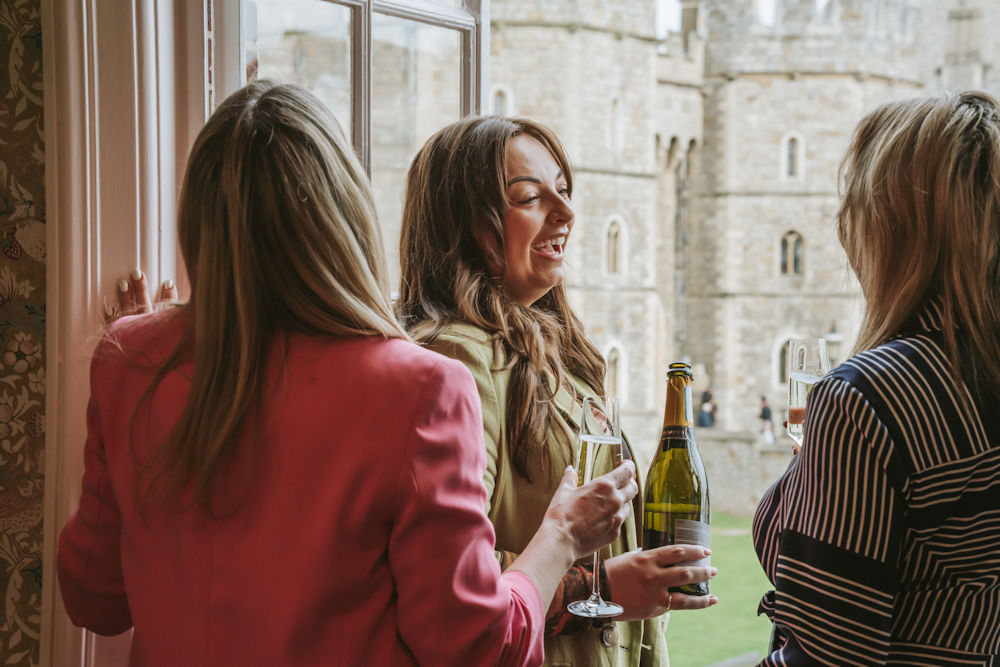 People drinking champagne at Cecily Spa with Windsor Castle in the distance
