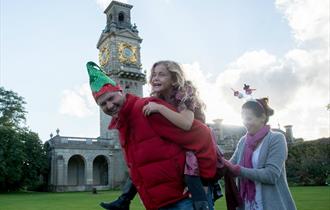 Family in Christmas costume in front of National Trust Cliveden's clocktower.